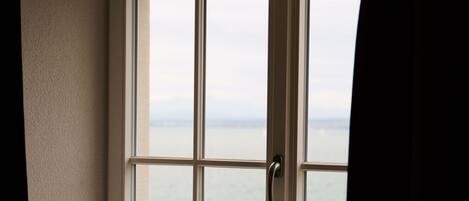 Une fenêtre donnant sur la mer et la verdure.