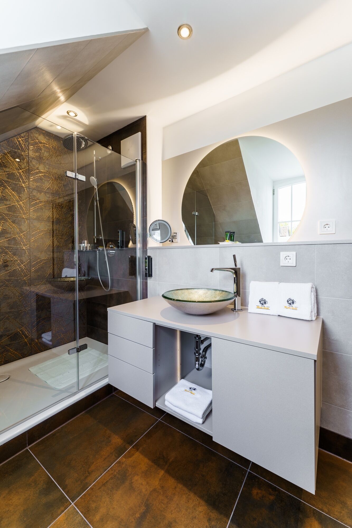 A modern bathroom with a glass-enclosed shower, a large mirror, and a vessel sink.