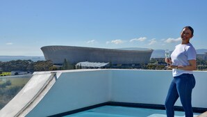 A person standing by a swimming pool with a modern building in the background. - ANEW Hotel Green Point (Cape Town)