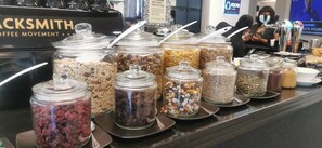 A coffee shop counter with various jars of granola and nuts. - ANEW Hotel Green Point (Cape Town)