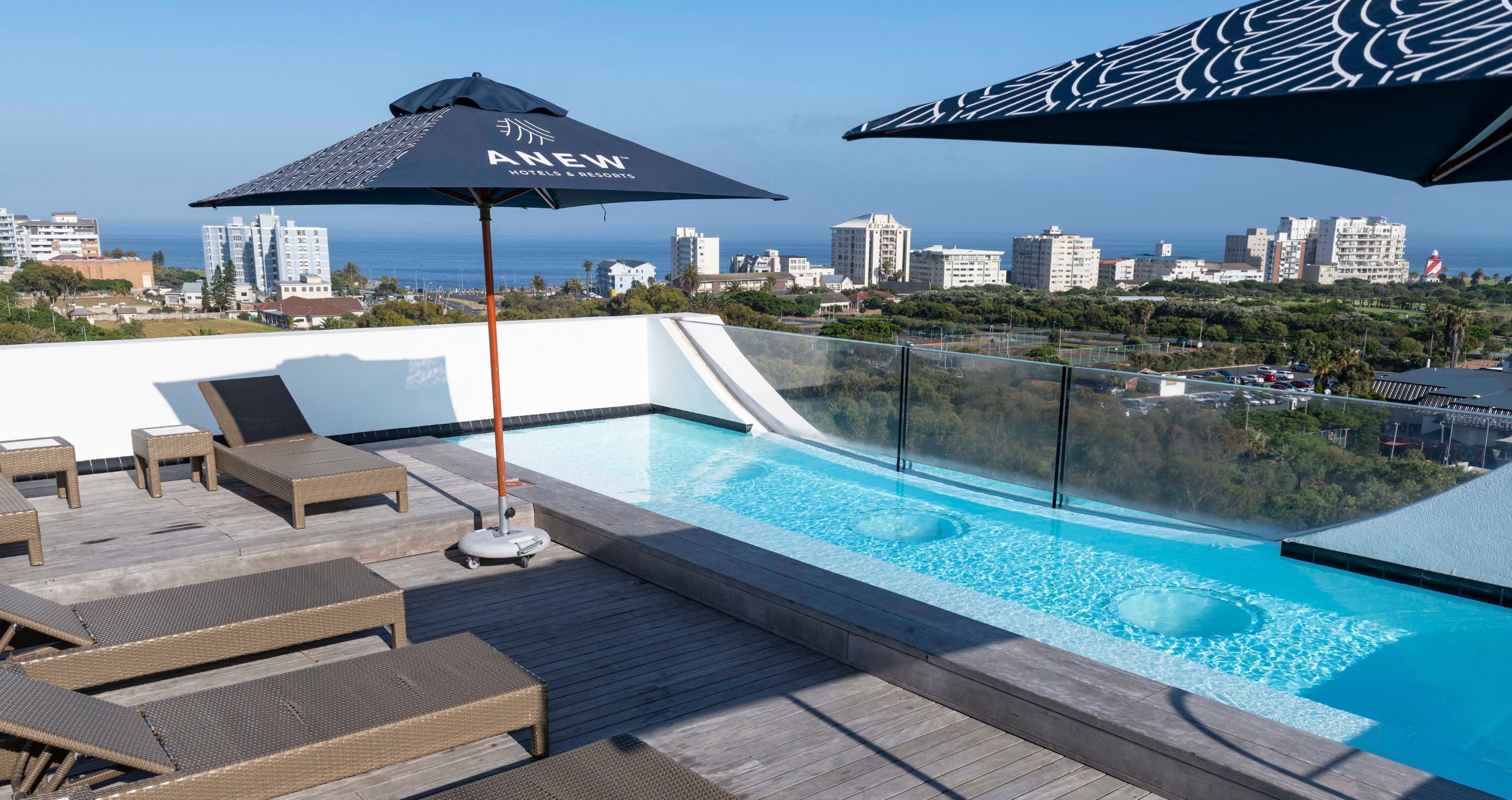 Una piscina al aire libre, sillones reclinables de piscina