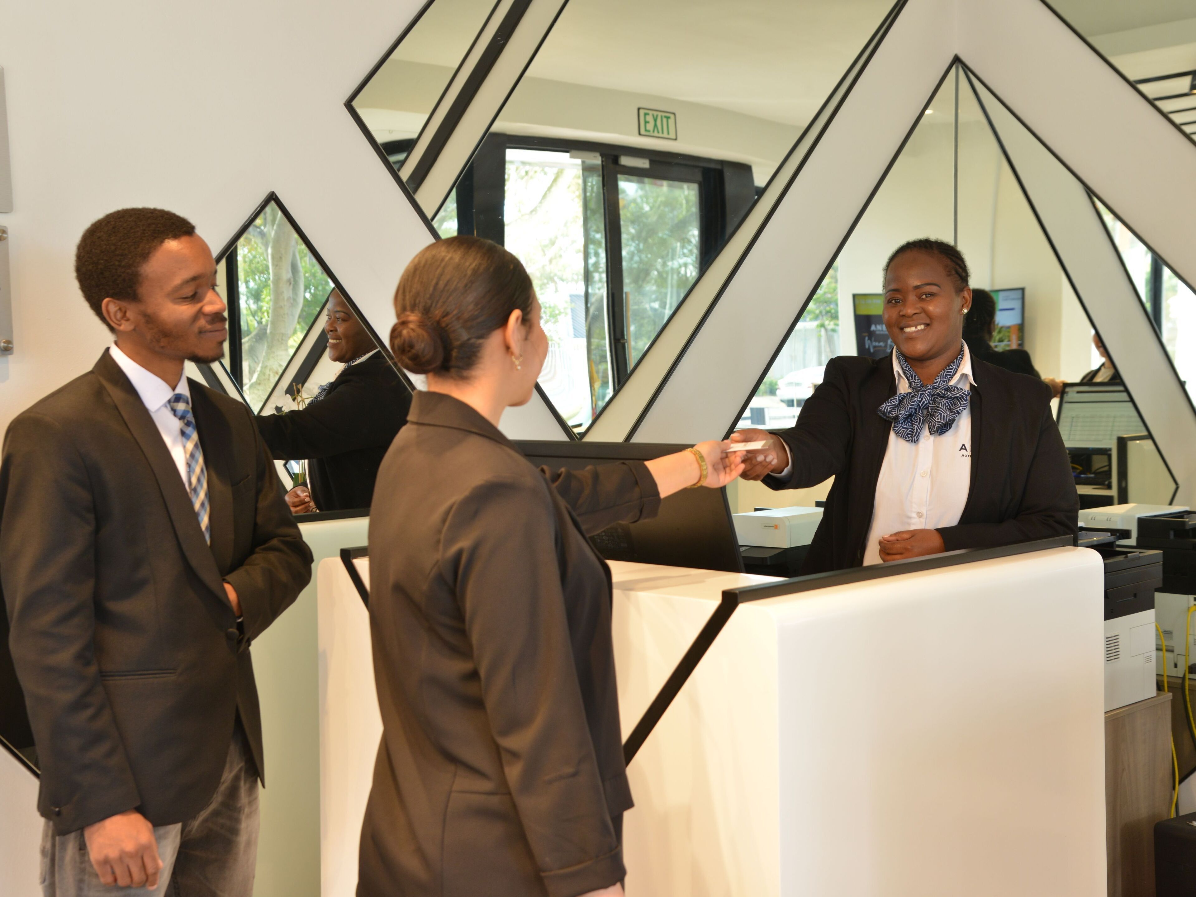 A reception area with a modern geometric design, a reception desk, and a computer.
