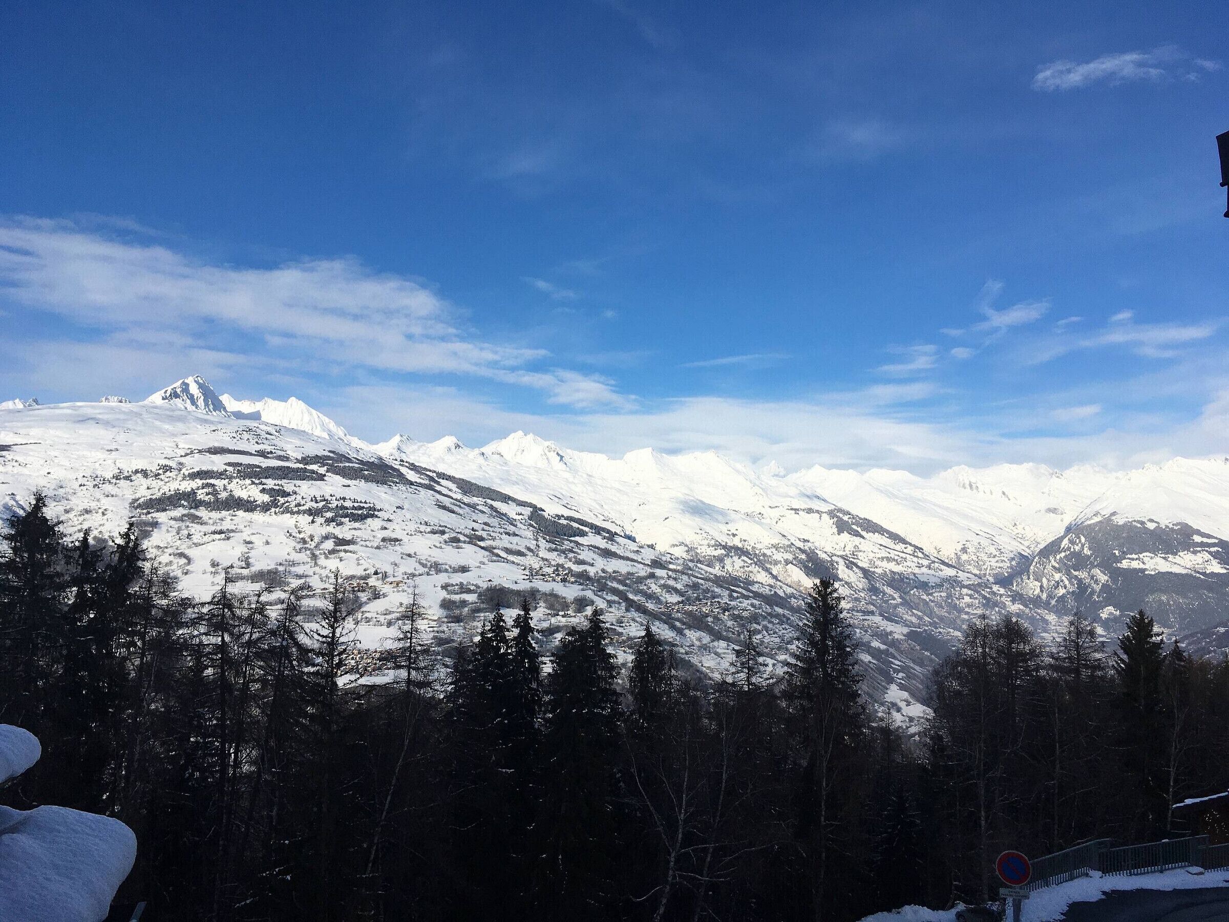 Eine verschneite Berglandschaft mit blauem Himmel.