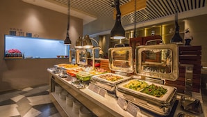 A buffet with various food items and a digital clock displaying the time. - Holiday Inn Express Shenzhen Nanshan by IHG (Shenzhen)