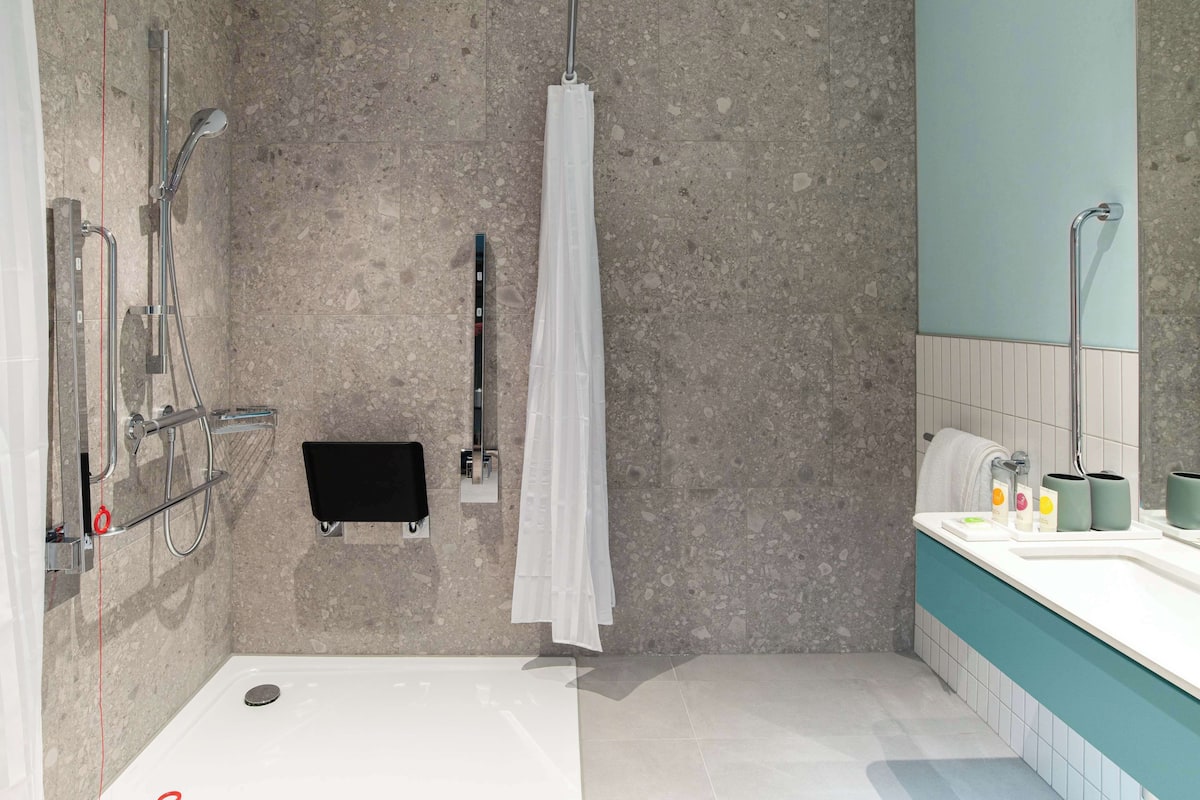 Une salle de bain moderne équipée d’une baignoire, d’une douche et d’un lavabo.