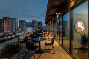 A rooftop terrace with tables and chairs, a city skyline view, and a sign for 'PS POCKETSQUARE SKYLINE BAR & TERRACE'. - Hyatt Place London City East (London)