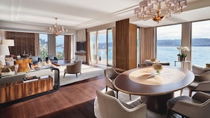 A spacious living area with a round dining table, comfortable seating, and large windows offering a view of the water. - Mandarin Oriental Bosphorus, Istanbul (Istanbul)