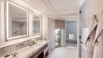 A modern bathroom with a large mirror, dual sinks, and a walk-in shower.