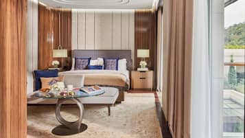 A modern hotel room with a large bed, a bedside table, a glass coffee table, and a view of a balcony.