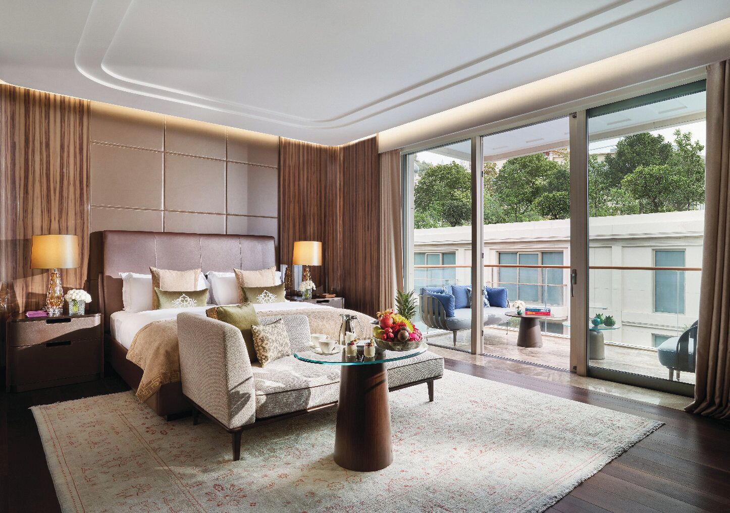 A spacious bedroom with a large bed, a coffee table, and a view of the outdoors.