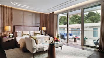 Un dormitorio espacioso con una cama grande, una mesita de centro y vistas al exterior.