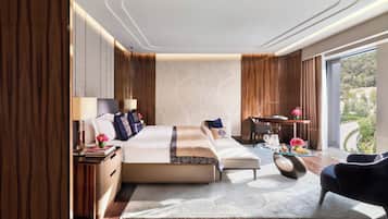 Una habitación de hotel moderna con una cama grande, un escritorio y vistas al exterior.