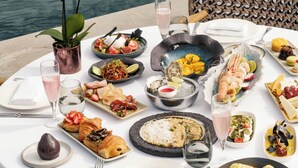 A table set for a meal with various dishes, a drink, and a view of the water. - Mandarin Oriental Bosphorus, Istanbul (Istanbul)