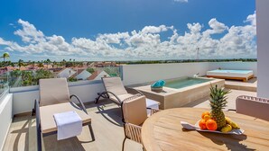 A rooftop terrace with lounge chairs, a hot tub, and a table with fruit. - Elegant and spacious Penthouse with View (Punta Cana)