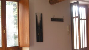 A room with a radiator, a wooden ceiling beam, a window with blinds, and a door with a window. - GREEN RELAX II THE GREEN OF THE HILL (Torino)