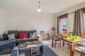 Un salon comprenant un canapé, une table basse et une table à manger avec des chaises.