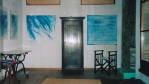 Una habitación con techo de madera, una puerta y dos sillas.