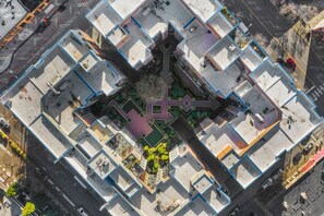 An aerial view of a modern apartment complex with a central courtyard, surrounded by individual units. - Corner Unit in the middle of it all - 99 Walkscore! (Seattle)