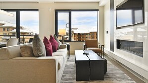 A modern living room with a sofa, armchairs, a coffee table, and a fireplace. - New 1 BR Residence in Canyons Village- Ski in/out by RedAwning (Park City)