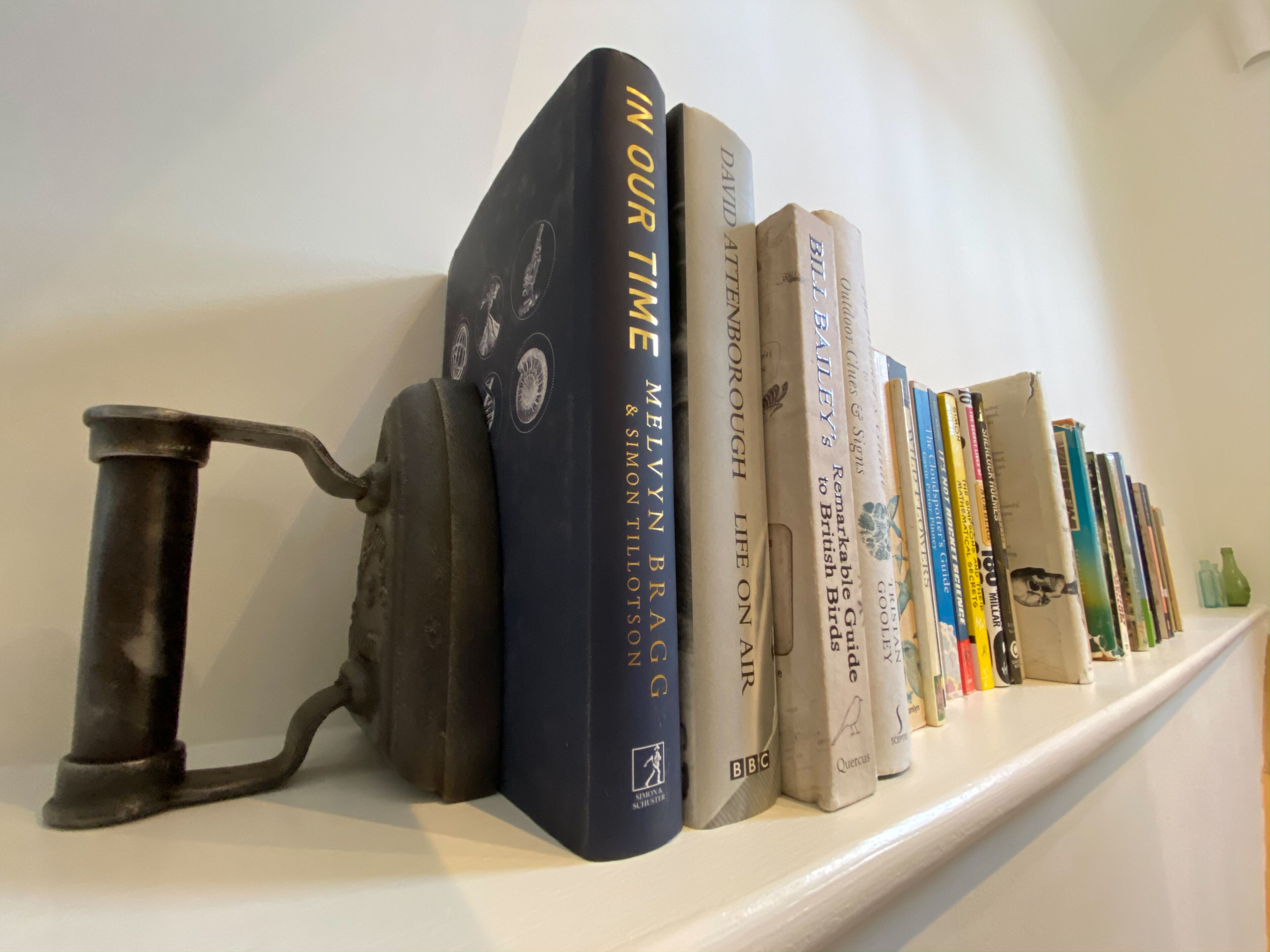 A shelf with books and a vintage typewriter.
