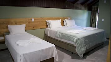 Una habitación con dos camas individuales, cada una con cabecero de madera y ropa de cama blanca.