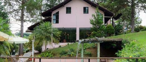 A two-story house with a swimming pool in the foreground.