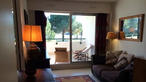 A living room with a sofa, two lamps, a coffee table, and a patterned rug. - 2 ROOMS+CABIN-AIR CONDITIONING- SWIMMING POOL- SOUTH-FACING TERRACE- LOVELY LAKE VIEW, WIFI. (La Grande-Motte)