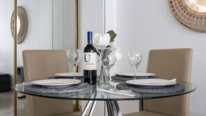 A dining table with four plates, a bottle of wine, and two glasses. - Luna Llena Beach 1BDR Oceanview Pool (Isla Verde)