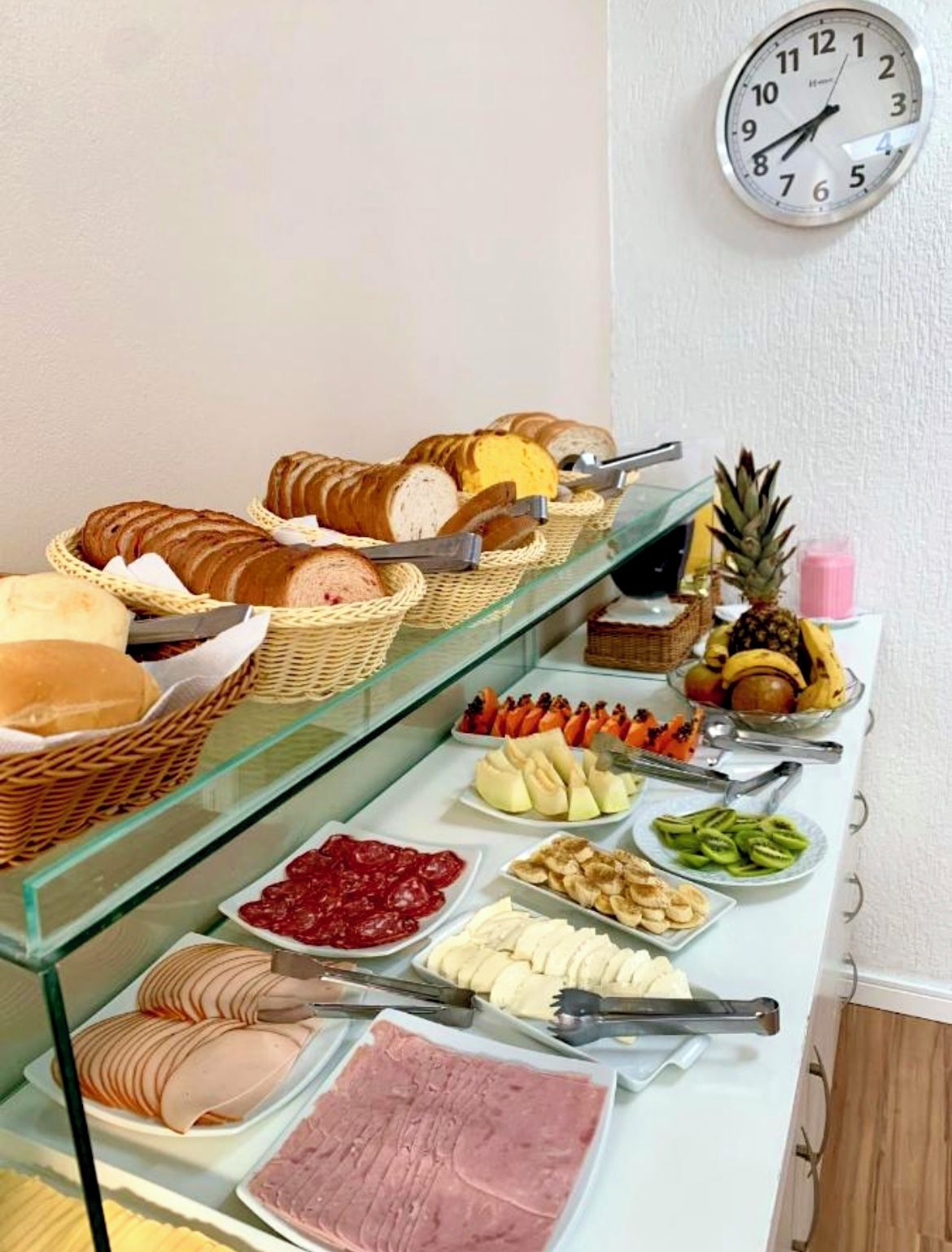 Un bufé con diversas opciones de comida, como pan, frutas y carnes.
