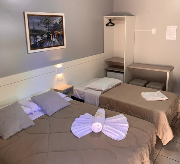 A hotel room with two beds, a nightstand, a desk, a wardrobe, and a painting on the wall. - Pousada Bello  Outono (Canela)