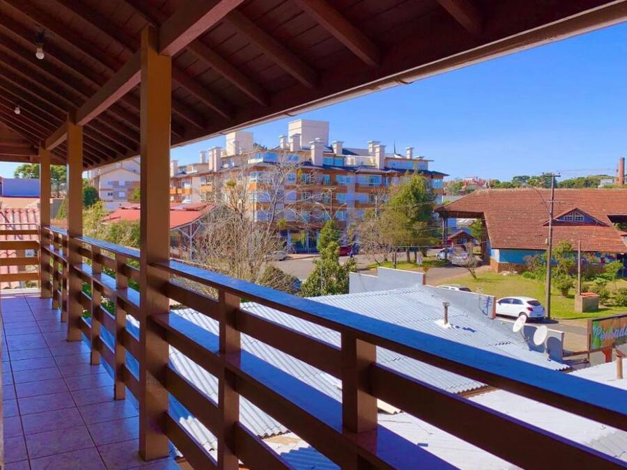 Un balcón techado con vistas a una zona residencial y un edificio con varios balcones.