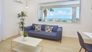 A modern living room with a blue sofa, white coffee table, and potted plants. - VILLA CIURIDDA (Alcamo)