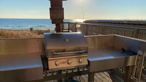 En grill med en træterrasse og havudsigt.