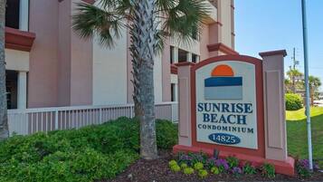 A sign for Sunrise Beach Condominium with a number 14825.