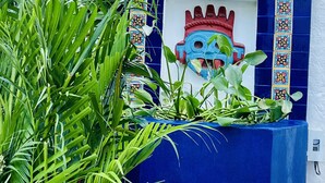 A blue planter with a decorative tile mural, surrounded by lush green foliage. - 2 bed, 2 bath house w/ private pool, pyramid waterfall, short walk to beach. (Barra de Navidad)