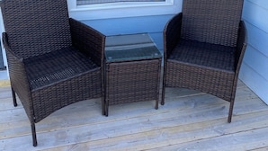 A porch with two wicker chairs and a small glass table. - 2 blocks to the beach- Pool- King-sized beds- Sound- SUPs- Linens- Beachgear (North Topsail Beach)