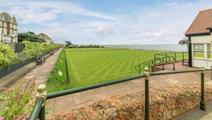 A seaside promenade with a lawn, benches, and a stone wall. - Heacham Hidey Hole, Heacham, Norfolk (Heacham)