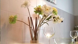 Een aanrecht met een groene tafelkleed, een vaas met bloemen en een bordje 'ONE WAY' erboven.