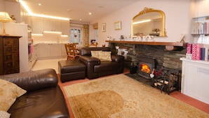 Una sala de estar acogedora con chimenea, sofá de cuero y un tapiz grande.