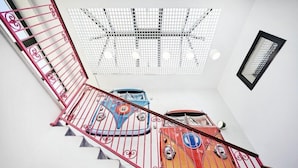 Una escalera con barandilla roja y una estructura en el techo.