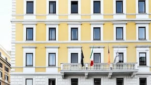 Un edificio de varios pisos con fachada amarilla y detalles blancos.