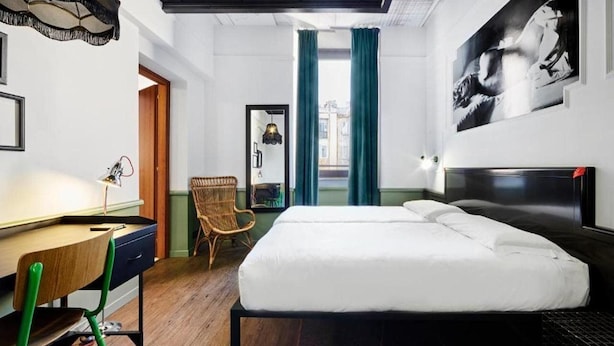 Un dormitorio moderno con cama, escritorio y silla.