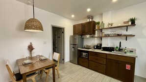Una cocina moderna con armarios de madera, una mesa de comedor y una lámpara colgante.