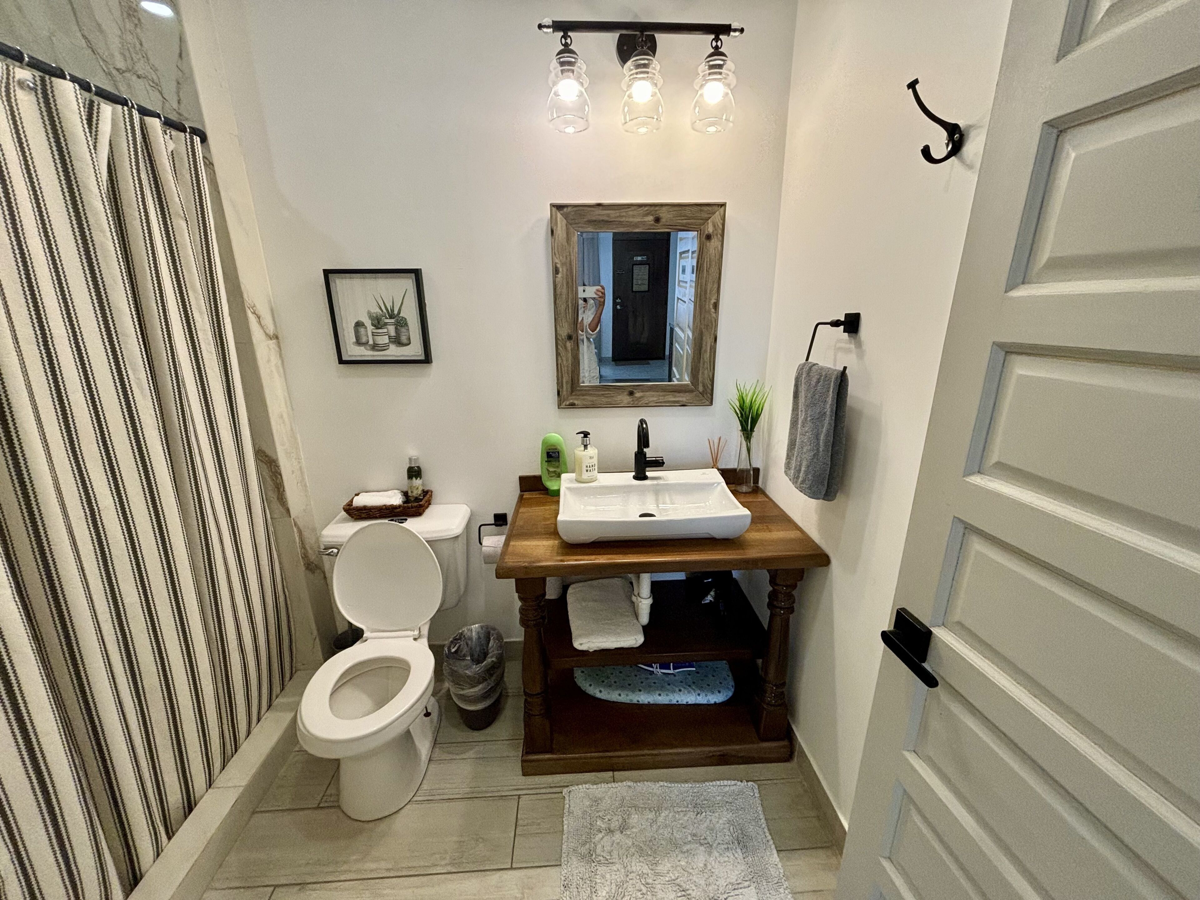 A compact bathroom with a toilet, sink, and shower.