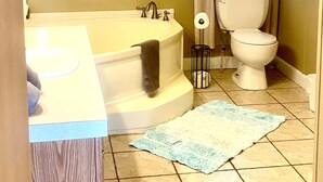 Une salle de bain avec une baignoire, des toilettes et un lavabo.