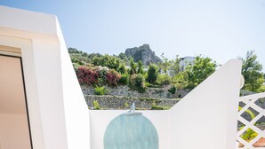 A small, enclosed shower area with a green tiled floor and a blue-tiled shower wall, adjacent to a white door. - La Gemma di Praiano (Praiano)