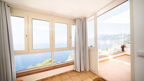 A room with a large window offering a view of the sea and hills. - La Gemma di Praiano (Praiano)