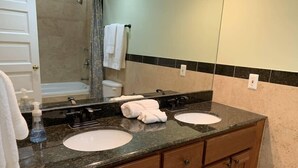 A bathroom with two sinks, a mirror, a shower, and a towel rack. - Studio flat in the heart of Chicago's Gold Coast (Chicago)