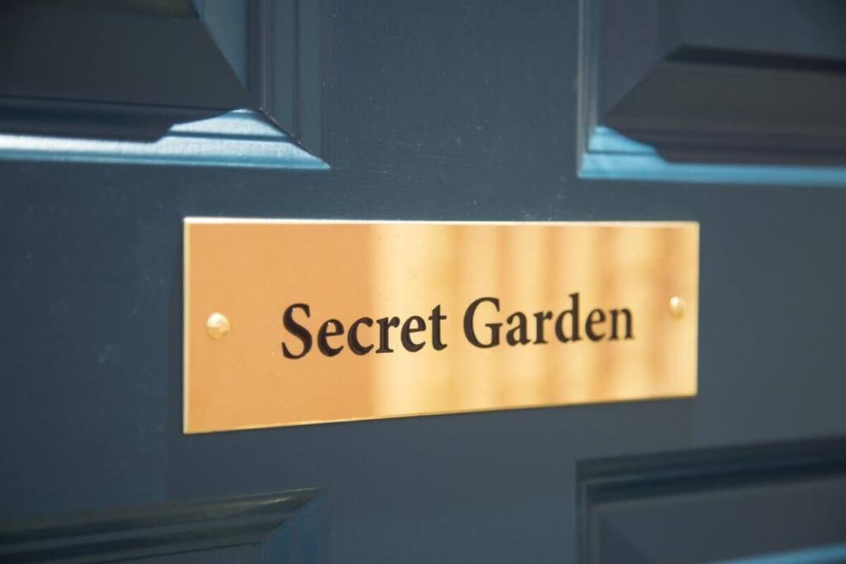 A sign labeled "Secret Garden" on a dark door.