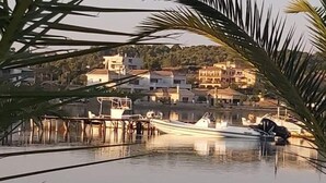 A marina with boats docked, a pier extending into calm water, and buildings in the background. - Amazing 2-bedroom Apartment Close to all Amenities (Ermionida)